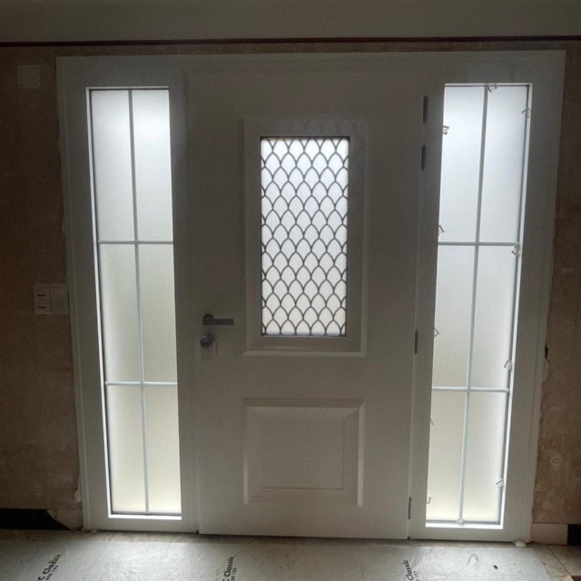 Serrure motorisée Nuki et grille décorative sur porte aluminium