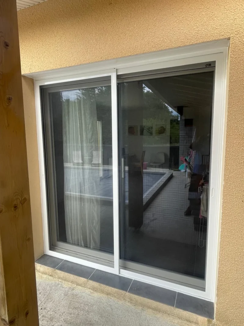 Porte-fenêtre coulissante avec moustiquaire et cadre blanc