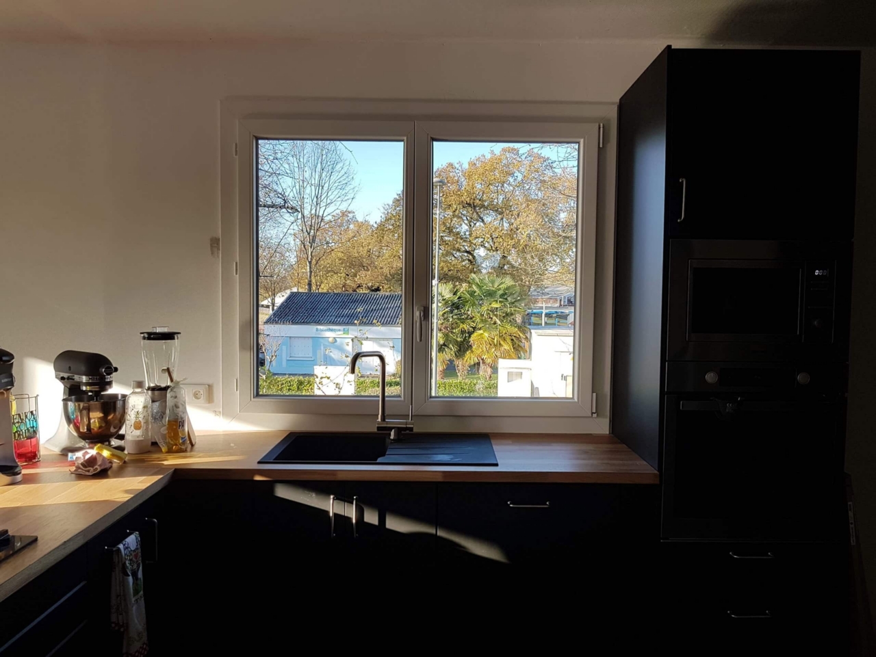Cuisine moderne avec fenêtre sur jardin ensoleillé