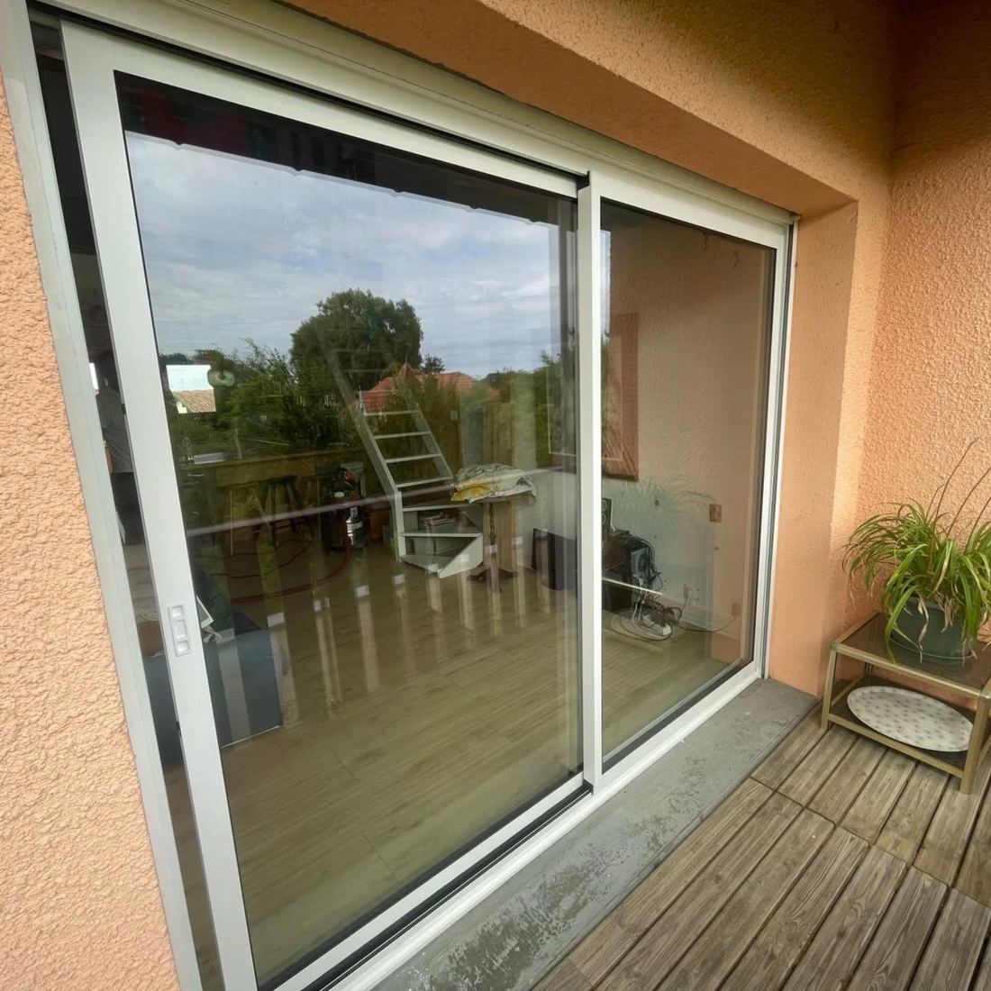 Baie coulissante en aluminium blanc ouvrant sur le balcon d'un appartement à Soustons