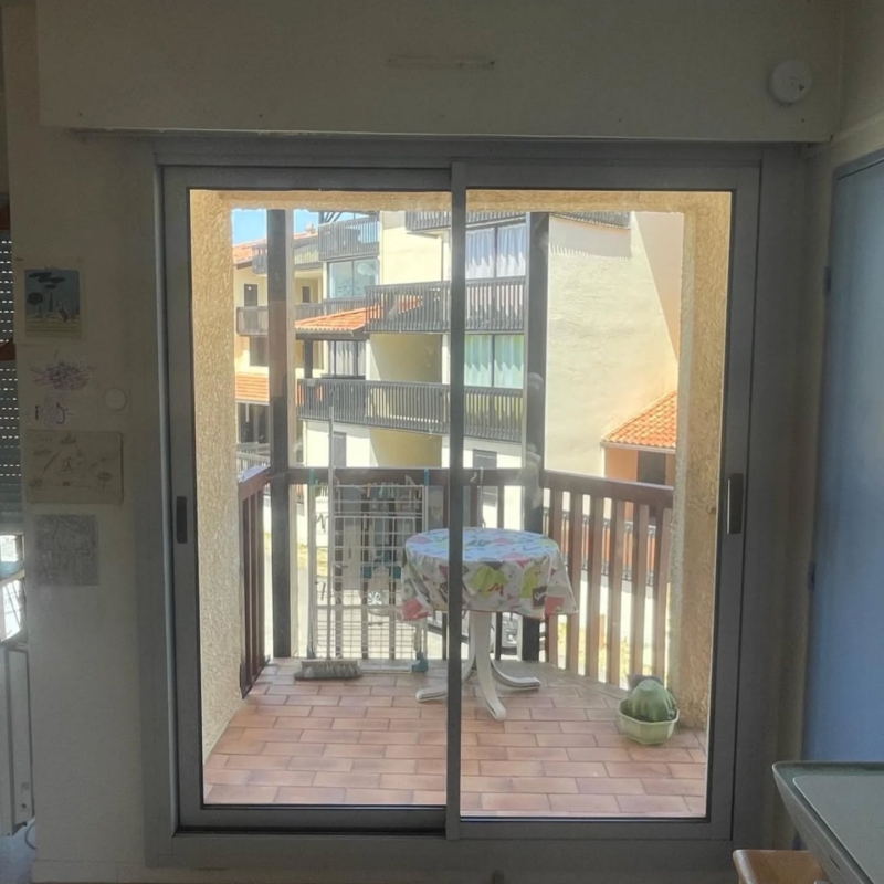 Baie vitrée alu gris ouvrant sur la terrasse d'un appartement à Vieux-Boucau