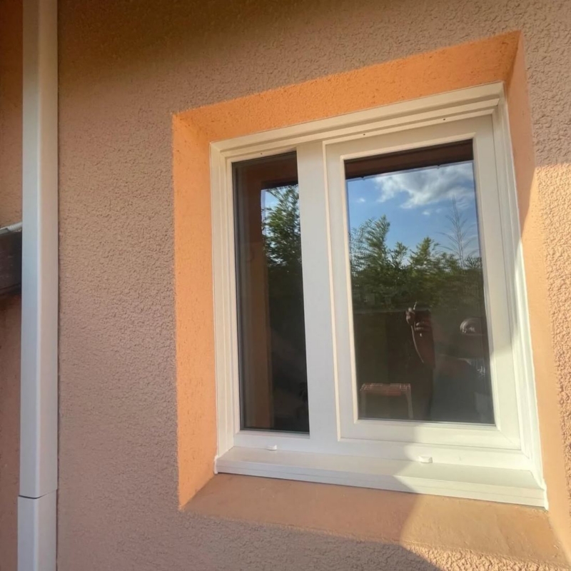 Fenêtre blanche sur façade pêche ensoleillée