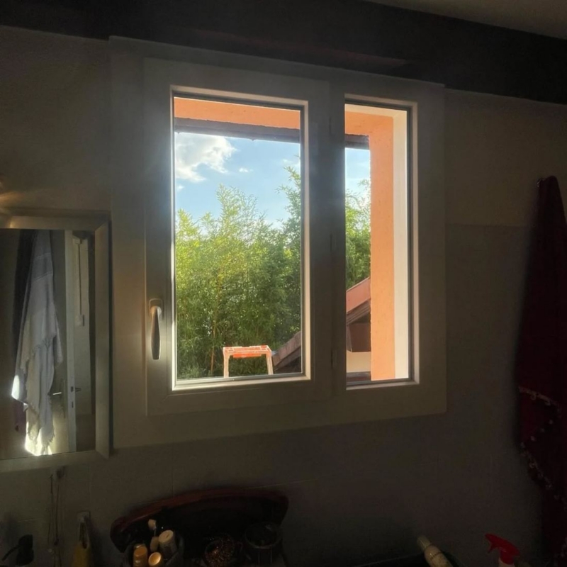 Fenêtre de salle de bain ouverte sur jardin ensoleillé