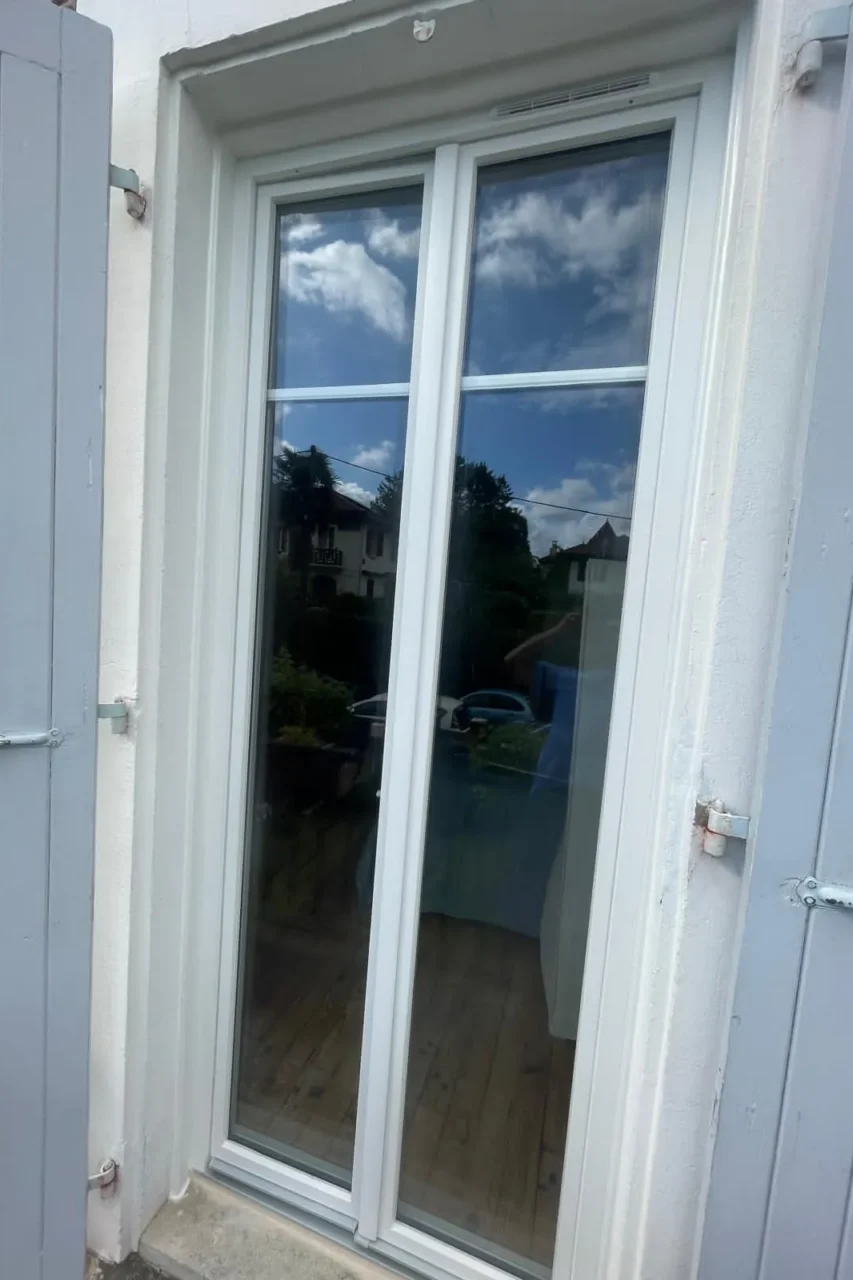 Porte-fenêtre blanche avec volets ouverts
