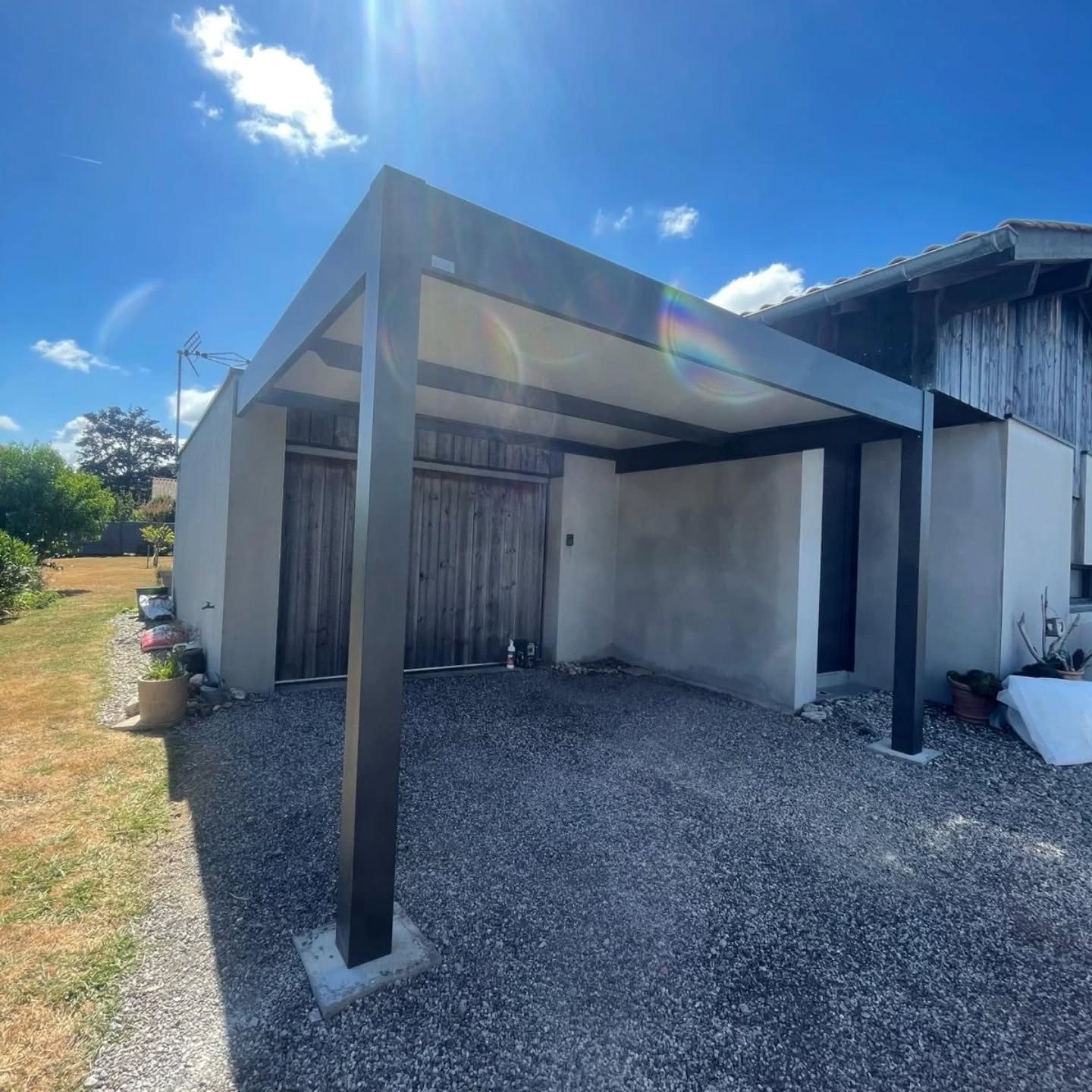 Carport en aluminium gris quartz posé par Hontabal à Ondres, adossé à une maison
