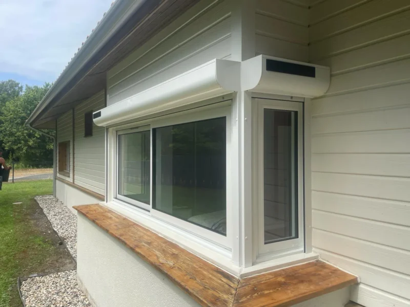 Menuiseries aluminium blanches posées en angle sur une maison à bardage bois à Moliets-et-Maa