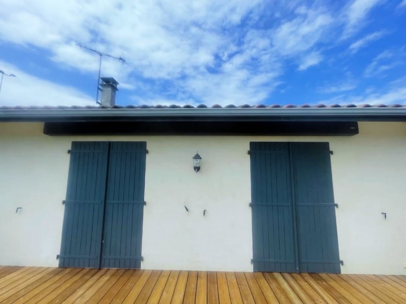 Coffre de store banne anthracite intégré sous la toiture d'une maison à Soustons, store replié