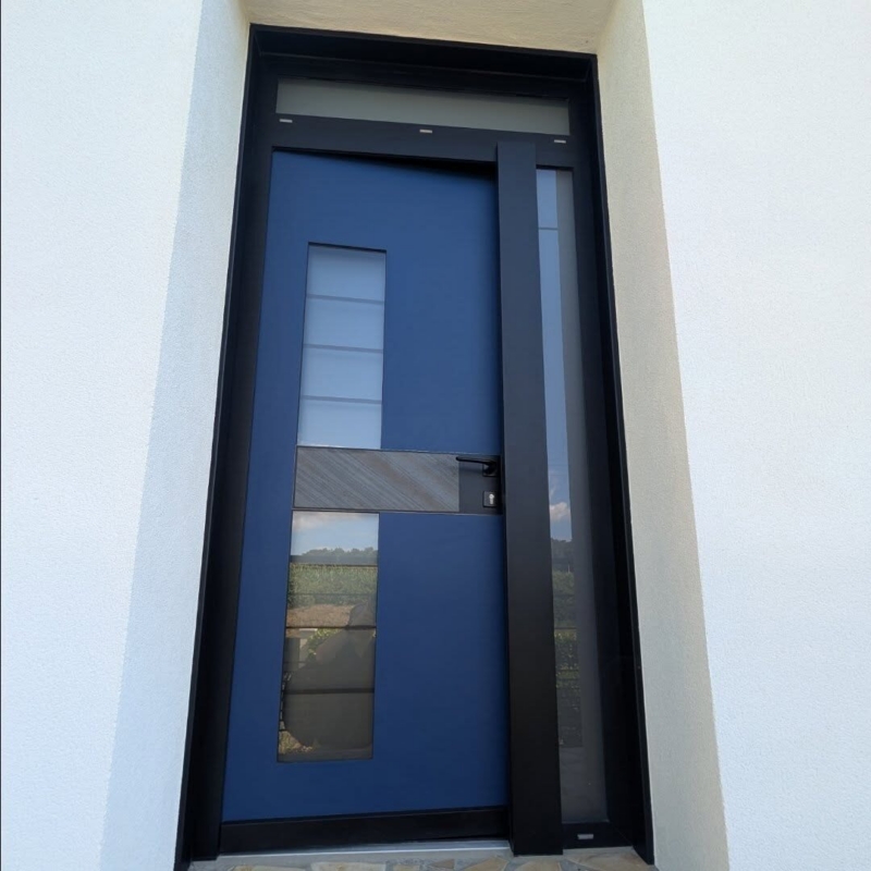 Porte d'entrée aluminium Monalu Samouraï bleue avec vitrage vertical et partie vitrée latérale, sud des Landes