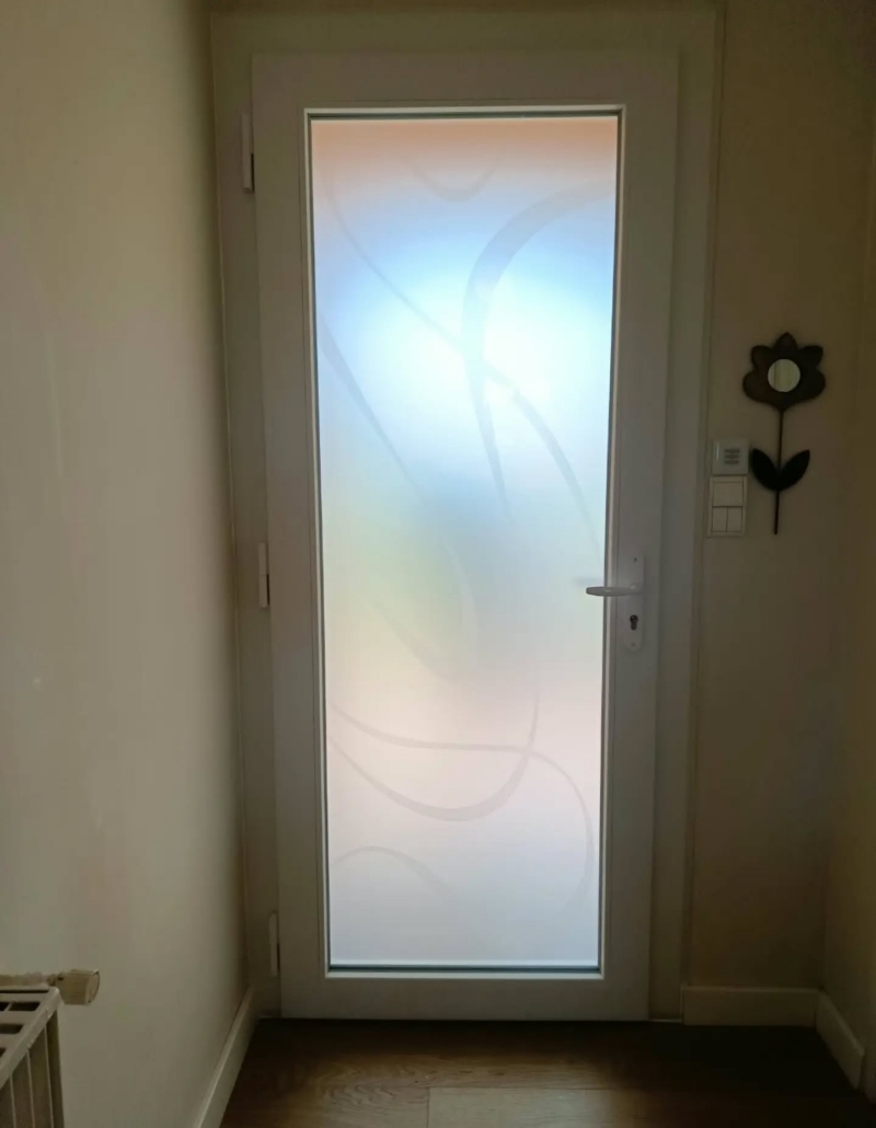 Porte d'entrée PVC vue de l'intérieur à Soustons : le vitrage dépoli à motifs gravés diffuse la lumière dans l'entrée