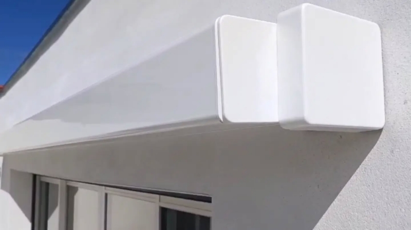 Gros plan sur le coffre intégral carré blanc d'un store banne posé sur une façade à Soustons